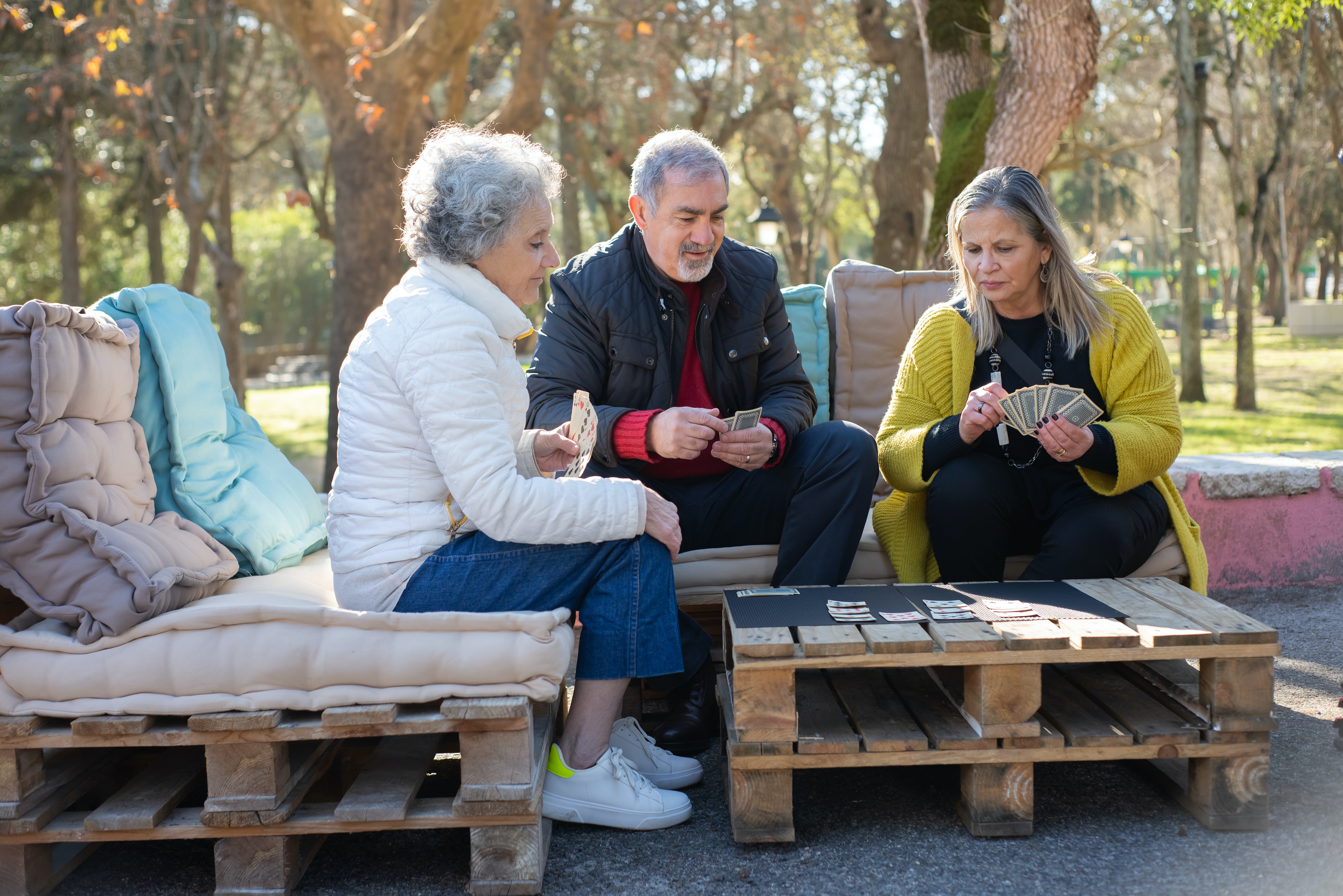 Seniors assis sur des palettes dans un jardin dans une résidence d'habitat inclusif